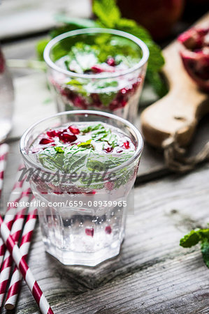 Detox drinks with lemon water, mint and pomegranate seeds