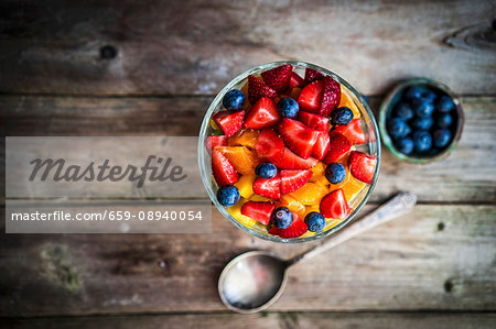 Colourful fruit salad in a jar on rustic wooden surface Colourful fruit salad in a jar on rustic wooden surface