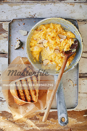 Scrambled egg with truffles in a pan with toast