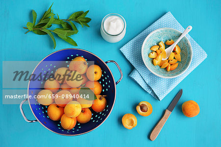 Fresh apricots in a colander and sliced in a bowl Fresh apricots in a colander and sliced in a bowl