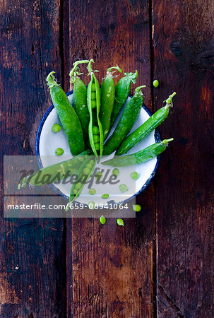 Freshly washed peapods in an enamel bowl