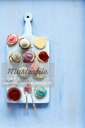 Biscuits with strawberry jam and icing (poppy seeds and almonds as decoration)