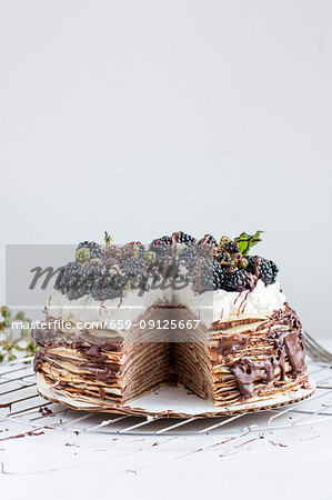 A pancake cake with chocolate and blackberries