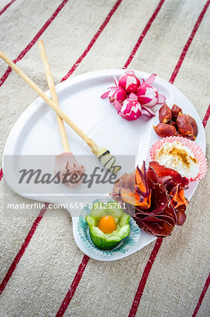 Painter's palette with radishes, chorizo, cheese mousse, bresaola and carrots, cucumber, ham, cherry tomato and bread sticks