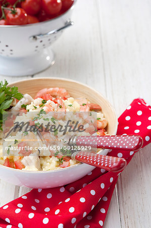 Seafood Risotto - with fish, muscles, prawns and parsley garnish; Cherry tomatoes in background