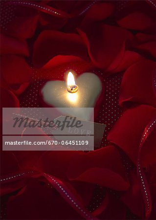 Heart-shaped candle and petals