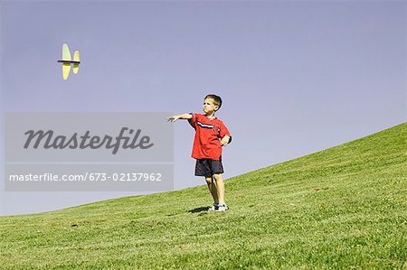 Young boy watching his model plane fly.