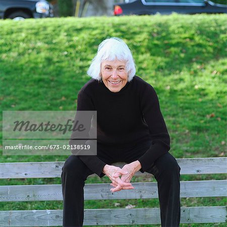 Portrait of a senior woman sitting on a park bench.