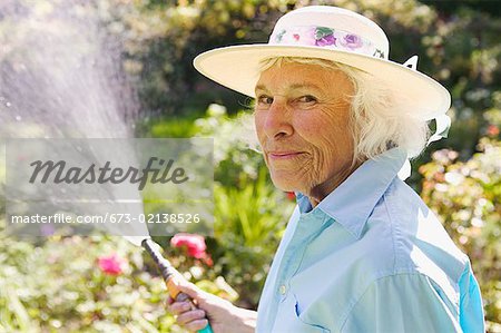 Senior woman watering her garden.