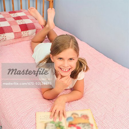 Young Girl Reading On Her Bed Stock Photo Masterfile