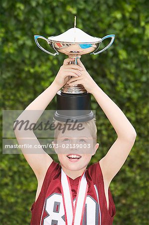 Boy balancing a trophy on his head