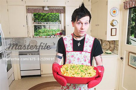 https://image1.masterfile.com/getImage/673-02139095em-man-in-kitchen-holding-a-casserole-stock-photo.jpg