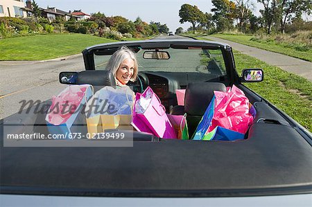 Woman with shopping bags in convertible