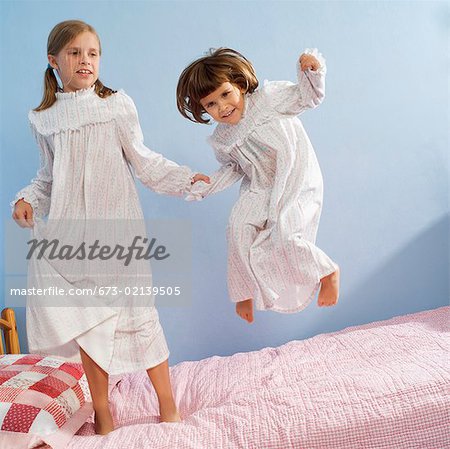 Girls jumping on bed