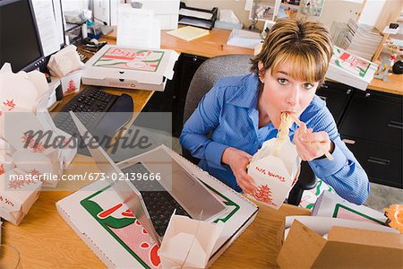 Office worker eating at her desk