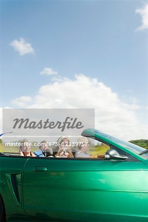 Family riding in convertible car