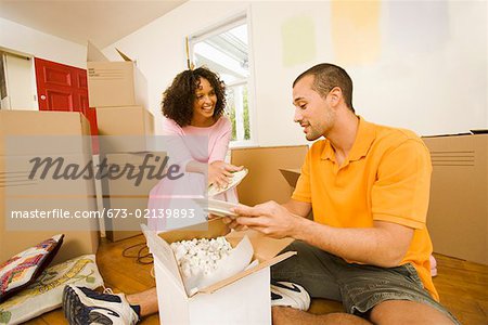 Couple unpacking boxes in new home