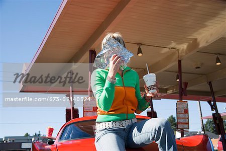 Woman eating at drive-in restaurant