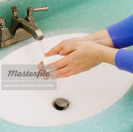 Closeup of washing hands in bathroom sink
