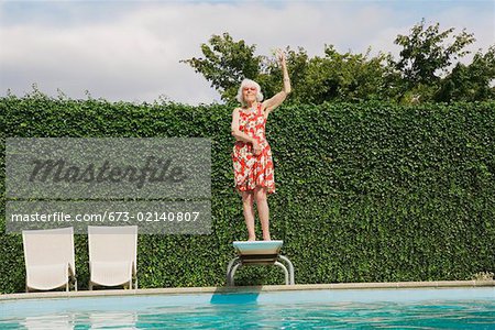 Elderly woman dancing on diving board