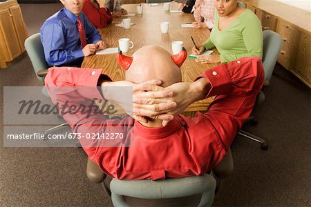 Businessman with devil horns at meeting