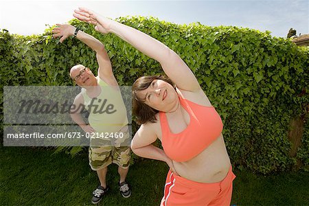 Couple stretching in backyard
