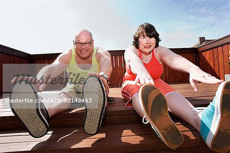 Couple stretching on patio