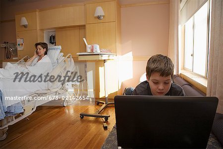 Young boy using a laptop in hospital room
