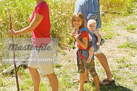 Girl carrying baby sibling on back