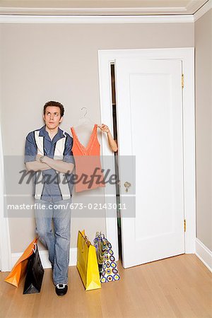 Hispanic man waiting for girlfriend in dressing room