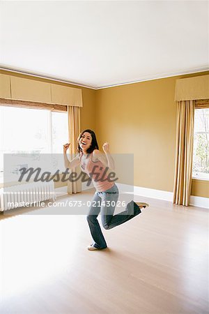 Hispanic woman dancing in new house