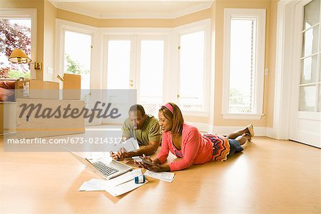 African couple paying bills in new house