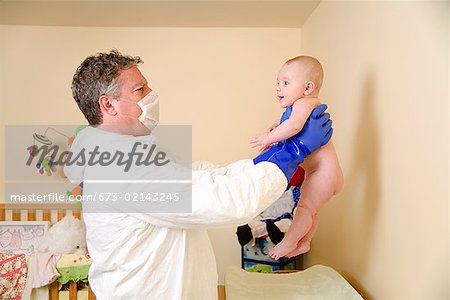 Father in decontamination suit holding baby