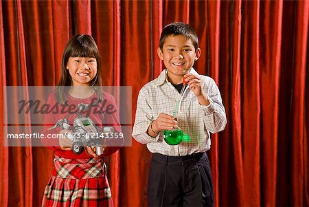 Asian boy and girl holding science experiments