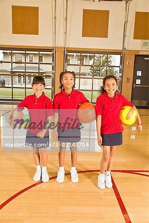 Multi-ethnic girls holding sports balls