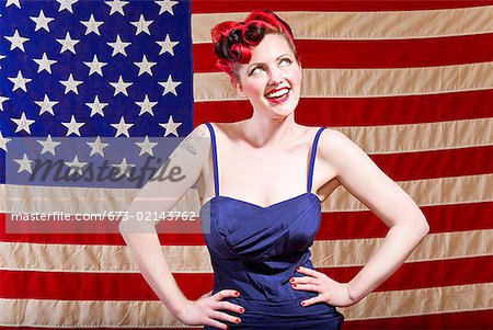 Woman with hands on hips in front of American flag