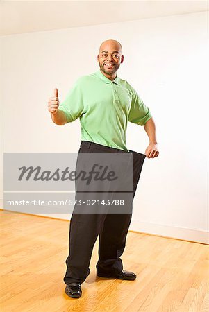 Man In Oversized Pants Showing Weight Loss Concept In Photo Picture And HD  Photos | Free Download On Lovepik