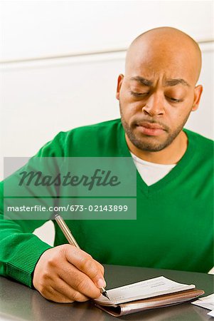 African man writing check