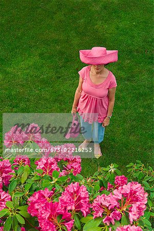 Woman in festive pink hat standing in garden