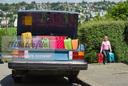 Car trunk loaded with colorful suitcases