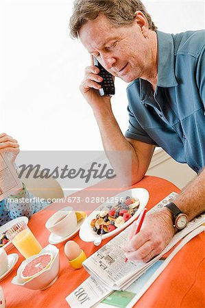 Couple having breakfast and checking classifieds
