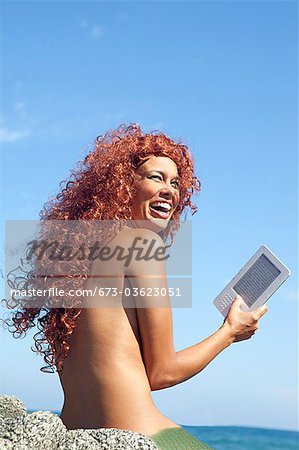 woman by sea with e-book