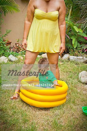 woman with young boy playing in pool