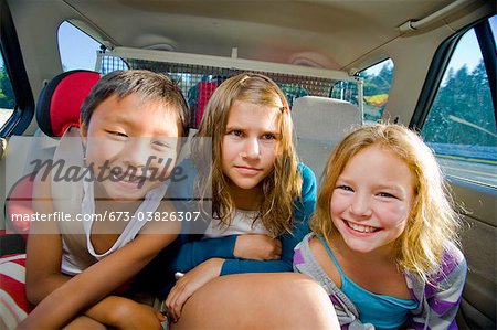 children making faces in car