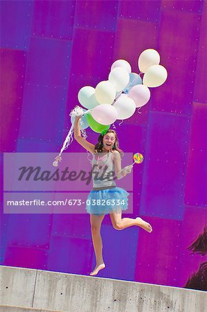 teen girl holding bunch of balloons