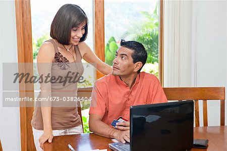 woman standing near man paying bills