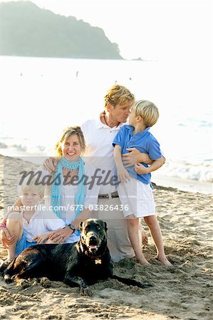 portrait of family on beach with dogs