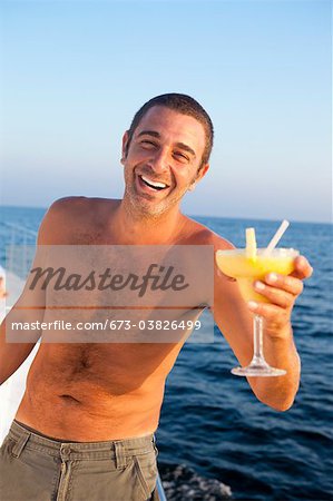 man with cocktail on yacht