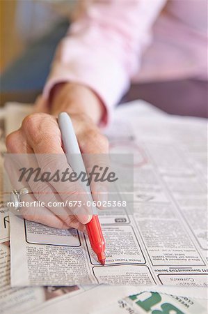 Woman circling employment ads in paper