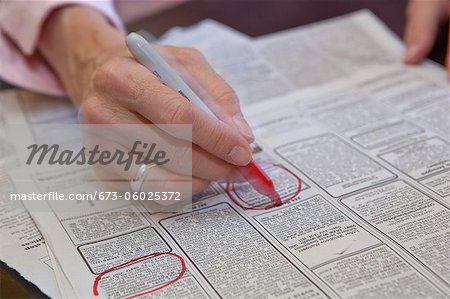 Woman circling employment ads in paper